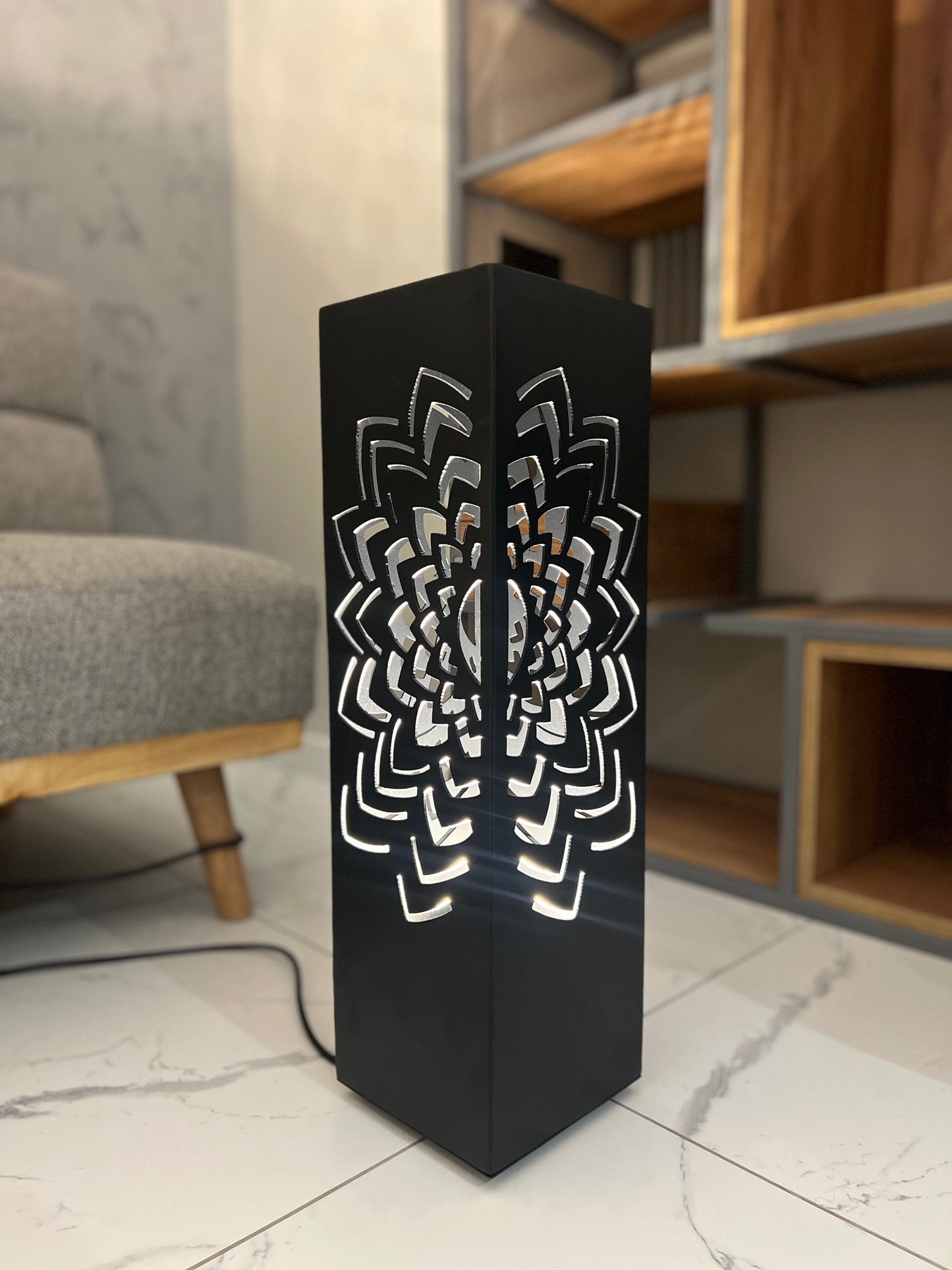 decorative metal floor lamp casting intricate light shadows on wall and floor at night